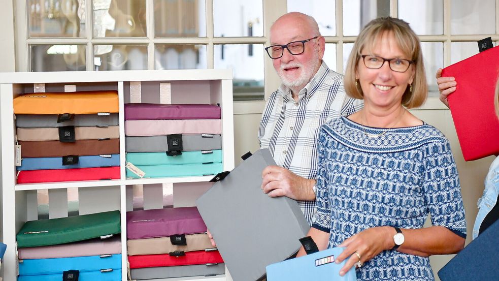 Der Kirchenratsvorsitzende von Rysum, Hartwig Peters, und Kirchenratsmitglied Elke van Hoorn schauen sich die neuen Sitzkissen genauer an. Foto: Wagenaar