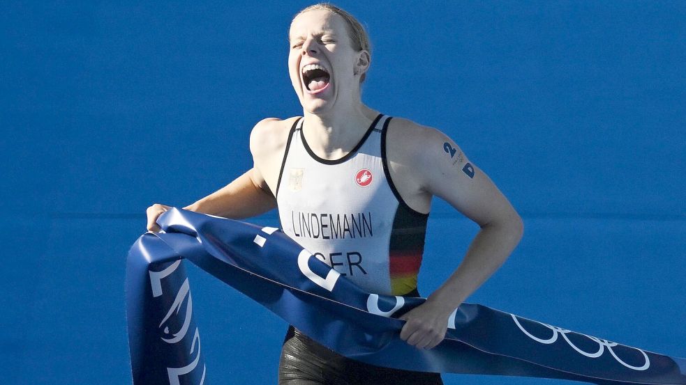 Laura Lindemann trägt bei der Schlussfeier der Olympischen Spiele gemeinsam mit Max Rendschmidt die deutsche Fahne. Foto: Marijan Murat/dpa