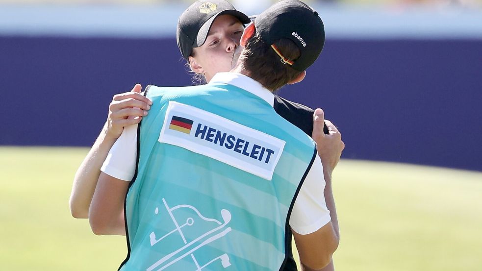 Esther Henseleit küsst ihren Freund und Caddie Reece Phillips. Foto: Jan Woitas/dpa