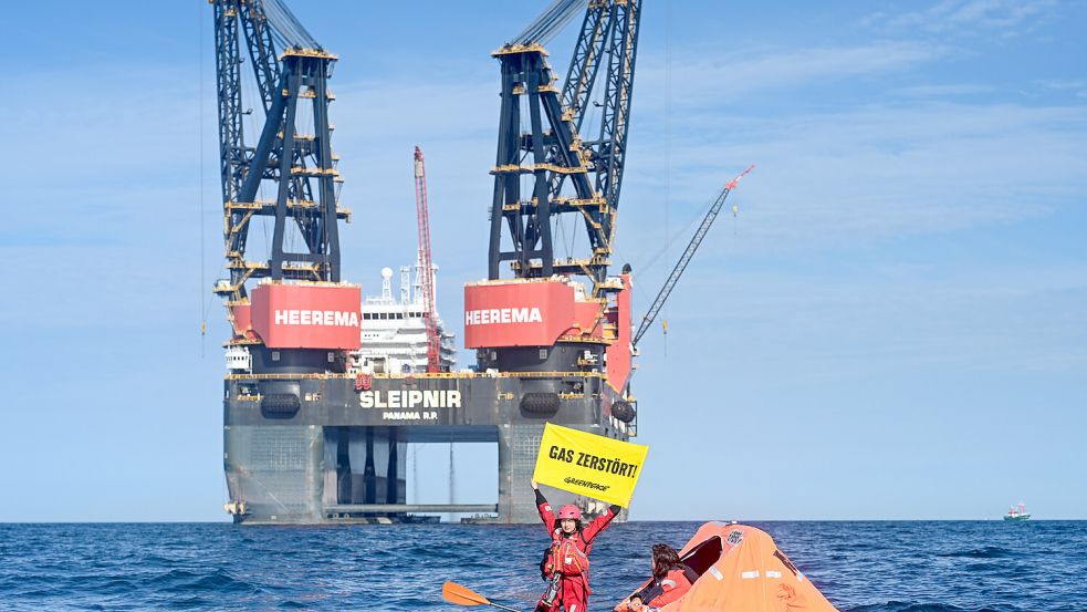 „Gas zerstört“ steht auf einem Banner einer Greenpeace-Aktivistin, die rund 20 Kilometer nordwestlich der Insel Borkum gegen die Förderung von Erdgas protestiert. Foto: dpa/Lars Penning