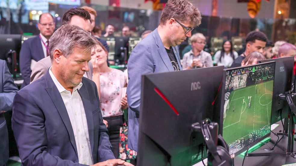 Der Bundeswirtschaftsminister Robert Habeck und sein Staatssekretär Michael Kellner (beide Grüne) spielen bei der Gamescom ein Fußballspiel zur Probe. Foto: Oliver Berg/dpa