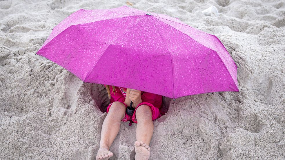 Ein Tag am Strand macht bei ständiger Regengefahr keinen großen Spaß. Doch das Wetter wird wieder besser. Foto: dpa/Jens Büttner