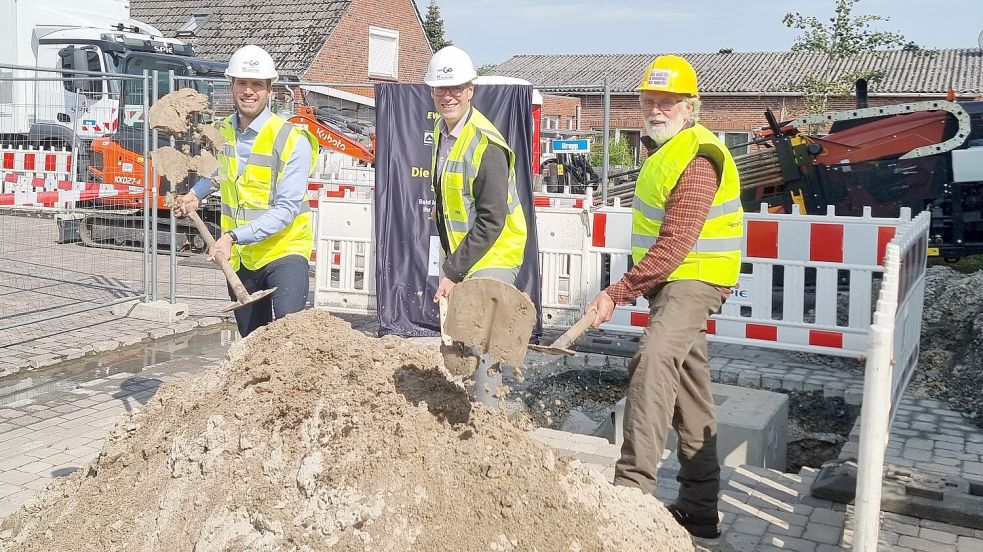 Symbolischer Spatenstich am Tichelmarkt (von links): Kevin Tortora Geschäftsführer der EWE Go Hochtief Ladepartner, Bürgermeister Heiko Abbas und Grundstückseigentümer Anton Fokken. Foto: Rehaag