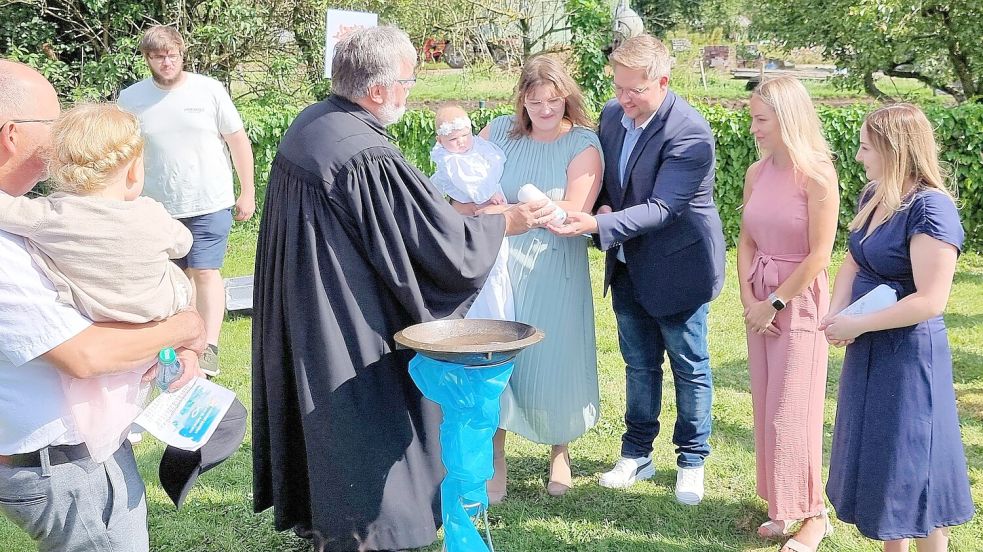 Marje Leni Berghaus aus Loga war eine von 39 Täuflingen bei der Mühle in Logabirum. Pastor Andreas Bartels sprach dem keinen Mädchen den Segen Gottes zu. Foto: Dübbel