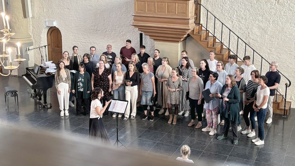 Chorleiterin Julia Grupe-Dörr (vorne am Notenständer) probt mit dem Chor Ligante und dem Vokalensemble Mixed Pickles für den erstmaligen gemeinsamen Auftritt. Fotos: Hanssen