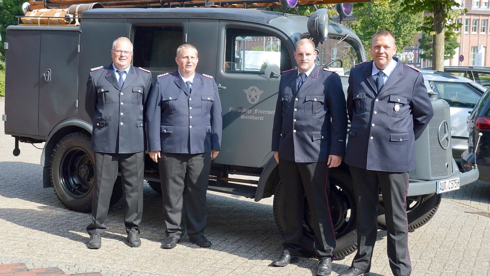 Beim Auricher Rathaus herrschte noch Ruhe, als die alten und neuen Sandhorster Führungskräfte (von links) Günter Wilts, Ingo Haase, Jann Gerdes und Harald Willms sich vor dem Feuerwehr-Oldtimer dem Fotografen stellten. Später brachte ein Unwetter Starkregen in die Region. Foto: privat