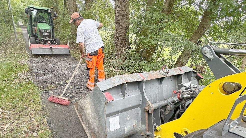 Mitarbeiter der Stadtwerke sind dabei, die Unebenheiten im Ostfriesland-Wanderweg zu entfernen. Foto: Stadtwerke Leer