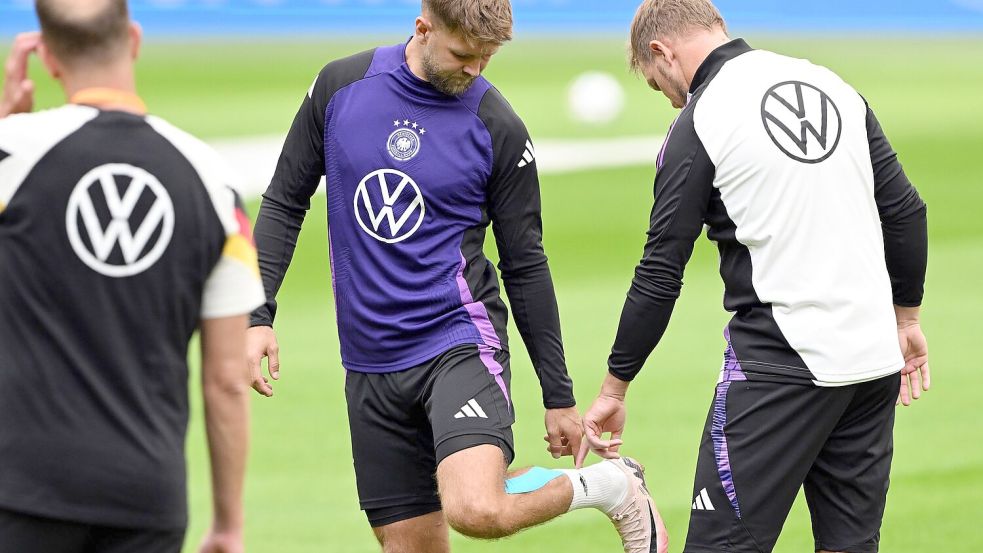 Niclas Füllkrug (M) nach seinem vergeblichen Härtetest beim Abschlusstraining im Gespräch mit Bundestrainer Julian Nagelsmann (r). Foto: Federico Gambarini/dpa