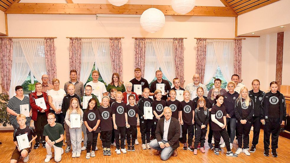 Uwe Theemann (Mitte, knieend) ehrte die Sportlerinnen und Sportler des Jahres. Mannschaft des Jahres sind die E-Fußballerinnen der JSG Ostfriesenkicker. Fotos: Stromann