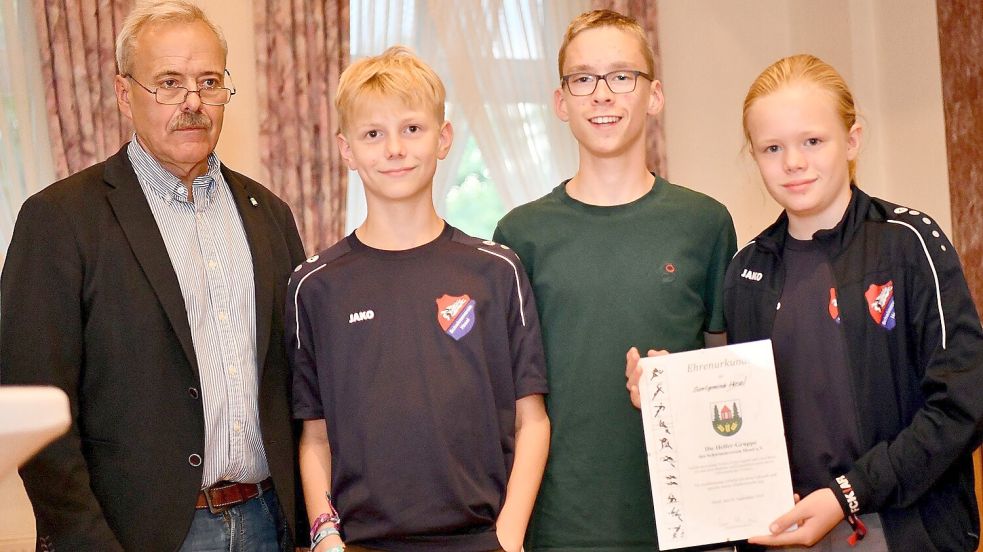 Wenn andere das Schwimmen lernen, achten Lennart Emken, Fynn Lippold und Linus Bruns vom Schwimmverein Hesel darauf, dass ihnen nichts passiert. Uwe Themann (links) überreichte den Jugendlichen eine Urkunde.