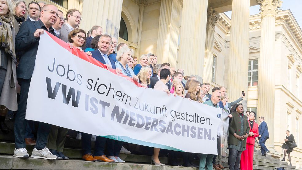 Auch die Politik möchte mal protestieren: Abgeordnete stehen am Mittwoch mit einem Banner „Jobs sichern. Zukunft gestalten. VW ist Niedersachsen“ als Solidaritätsaktion mit den Volkswagen Mitarbeitern vor dem niedersächsischen Landtag. Foto: Stratenschulte/DPA