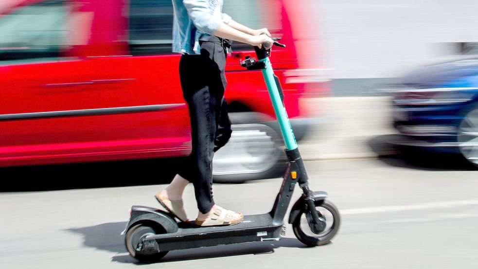 Eine junge Frau fährt mit einem E-Scooter. Foto: DPA