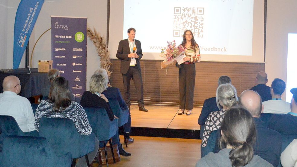 Jutta Martens (rechts) moderierte die Abschlussveranstaltung im Fehntjer Forum in Rhauderfehn. Sie steht auf der Bühne mit dem Chef von Orgadata aus Leer, Bernd Hillbrand. Foto: Weers