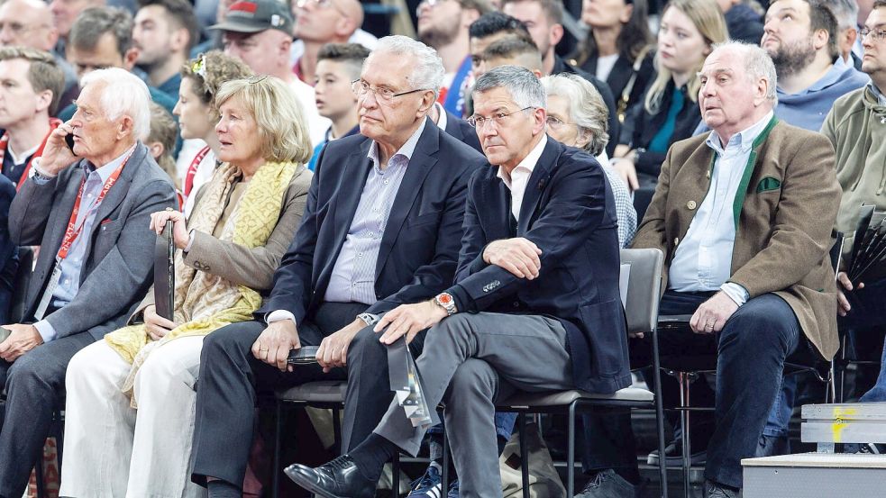 Einfache Stühle statt nobler Sessel für die VIPs: Bayerns Innenminister Joachim Herrmann, Vereinspräsident Herbert Hainer und Ehrenpräsident Uli Hoeneß. Foto: Matthias Balk/dpa