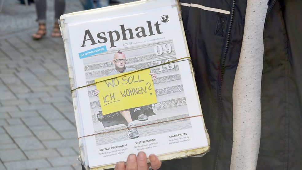 In Oldenburg hält ein registrierter Verkäufer eine Ausgabe hoch. Schon an vielen Details und am Verhalten der Verkäufer können Passanten die Echtheit erkennen. Foto: DPA/Anna-Lena Sachs