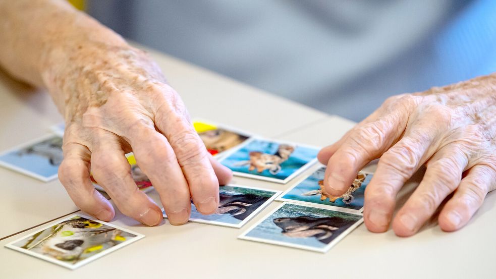 Gegen Lücken im Kurzzeitgedächtnis: Eine Bewohnerin eines Altenheims spielt auf einer Pflegestation „Memory“. Foto: Hoppe/dpa