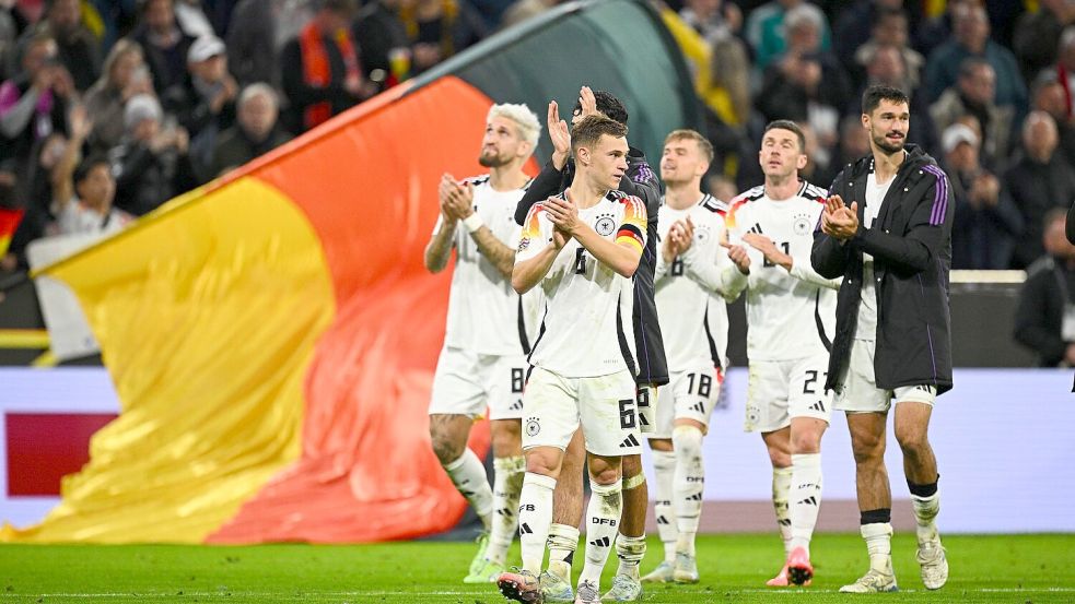 Glückliche deutsche Spieler um Kapitän Joshua Kimmich (vorne) auf der Jubelrunde durch das Stadion. Foto: Tom Weller/dpa