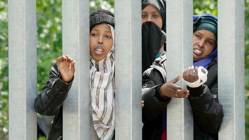 Migratinnen an der Grenzbarriere, die Polen entlang der Grenze zu Belarus errichtet hat. Warschau wil das Recht auf Asyl aussetzen. (Archivbild) Foto: Czarek Sokolowski/AP/dpa