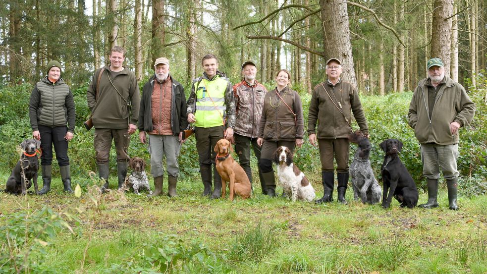 Das Foto zeigt die Prüflinge Malena Schulte mit Labrador „Kira“ und Arno Meinders mit Deutsch-Kurzhaar „Bautz vom Emsdeich“, Prüfungsleiter Heiner Kesting, Prüfling Thomas Hannen mit Magyar Vizsla „Frida“, Richter Gerhard Schulte, die Prüflinge Christine Bothe mit English Springer Spaniel „Deich Dogs Diana“, Frank Jeschke mit den Deutsch- Drahthaar-Hunden „Barne II vom Hintertief“ und „Boss II vom Hintertief“ sowie Richter Heini Haskamp. Foto: privat