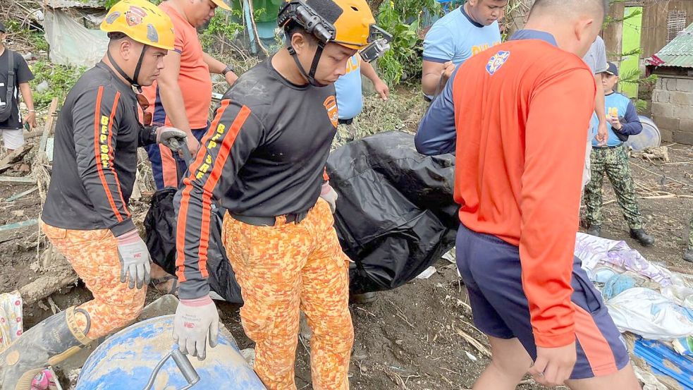 Rettungskräfte bergen eine Leiche nach einem Erdrutsch, der durch den Tropensturm Trami ausgelöst wurde Foto: Jim Gomez/AP/dpa