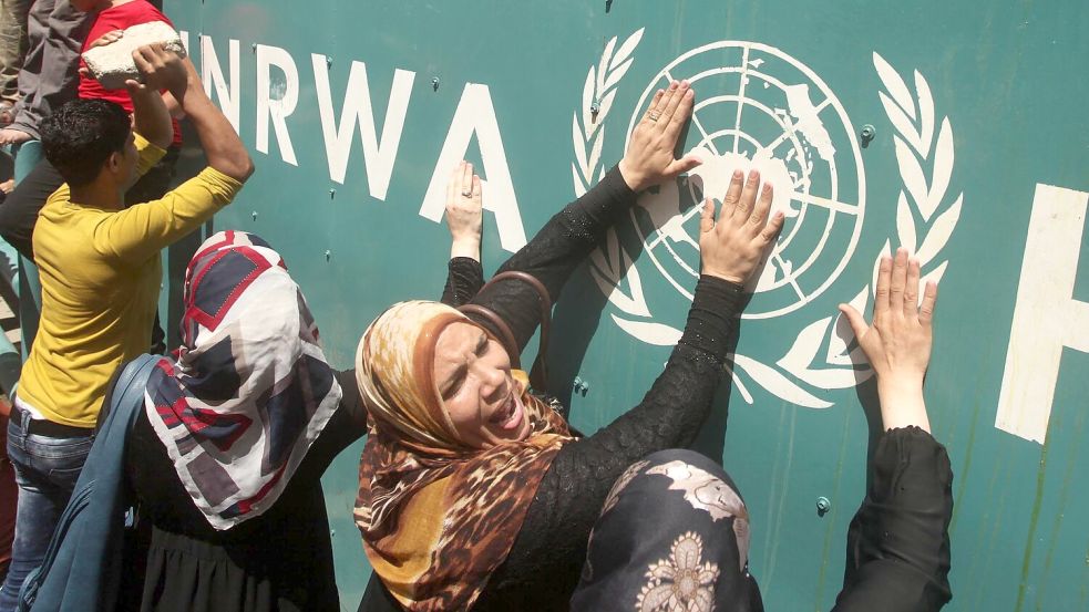 Palästinenserinnen vor UNRWA-Schild (Archivbild) Foto: Ashraf Amra/APA Images via ZUMA Wire/dpa