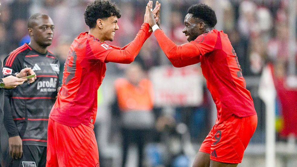 Der große Moment für Adam Aznou (l): Der 18-Jährige wird für Geburtstagskind Alphonso Davies eingewechselt, der sich mit dem Debütanten freut. Foto: Tom Weller/dpa