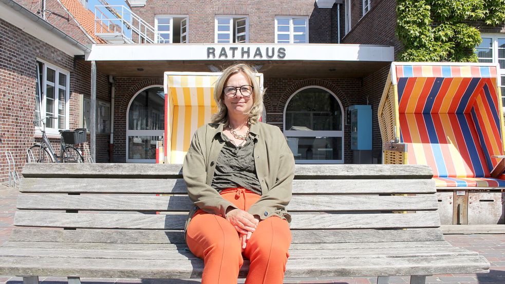 Heike Horn sitzt vor dem Rathaus auf Langeoog. Foto: Archiv/Oltmanns