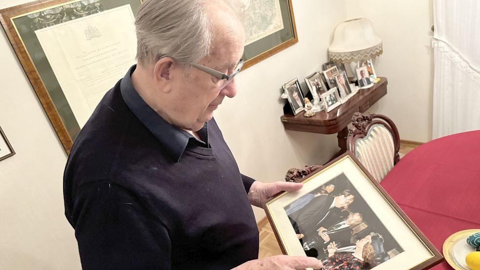 Johannes Riepma zeigt auf ein Bild, auf dem er gemeinsam mit der niederländischen Königin Beatrix zu sehen ist. Foto: Weiden