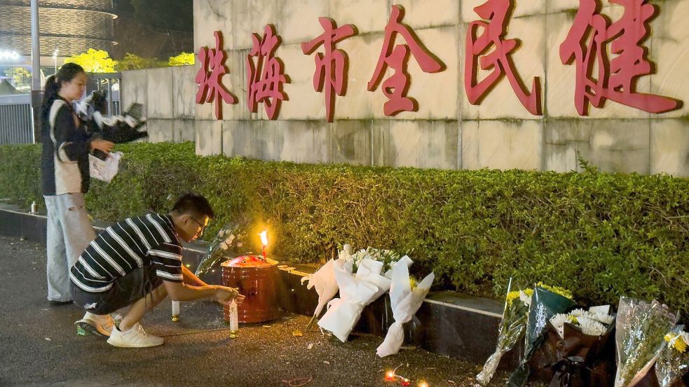 Menschen legen Blumen vor einem Sportzentrum nieder, wo ein Mann mit seinem Auto 35 Menschen tötete. Foto: Ng Han Guan/AP