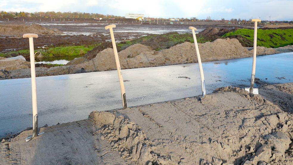 Als die wichtigen Männner zu den Spaten griffen, schien kurz die Sonne über dem bereitgelegten Sandhaufen auf Asphalt. Foto: Romuald Banik