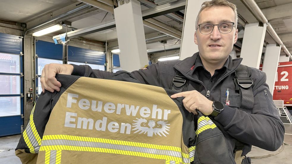 Das Emder Engelke stärkt symbolisch den Feuerwehrleuten auf der neuen Einsatzkleidung den Rücken. Hier hält Harald Janssen, Leiter der Hauptberuflichen Wachbereitschaft, eine der neuen Jacken hoch. Fotos: Hanssen