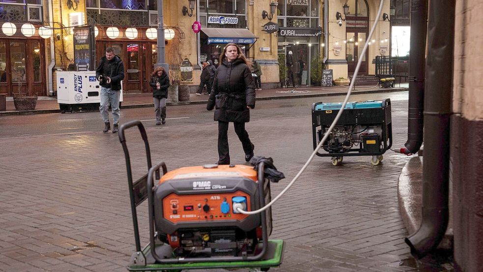 Die Menschen in der Ukraine behelfen sich bei Stromausfällen mit Generatoren. Foto: Evgeniy Maloletka/AP/dpa