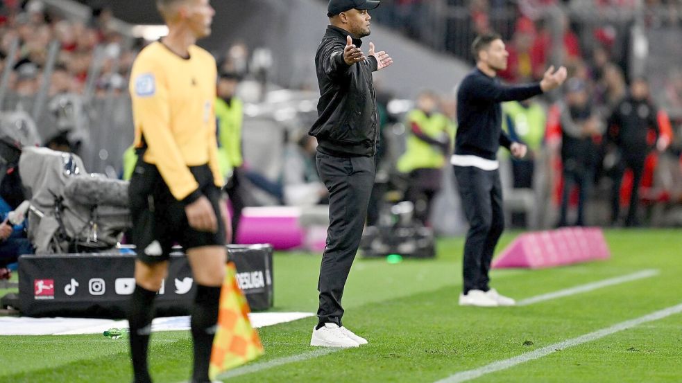 Schnelles Wiedersehen am Spielfeldrand: Bayern-Coach Vincent Kompany (M) und Leverkusens Meistertrainer Xabi Alonso (r). Foto: Sven Hoppe/dpa