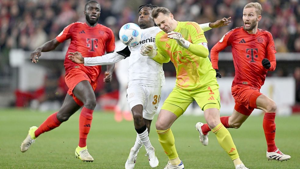 Der folgenschwere Moment: Manuel Neuer (r) kracht mit Leverkusens Jeremie Frimpong zusammen. Foto: Sven Hoppe/dpa