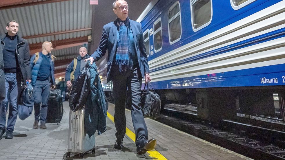 Merz ist mit dem Zug unterwegs - und stichelt gegen die Deutsche Bahn. Foto: Michael Kappeler/dpa