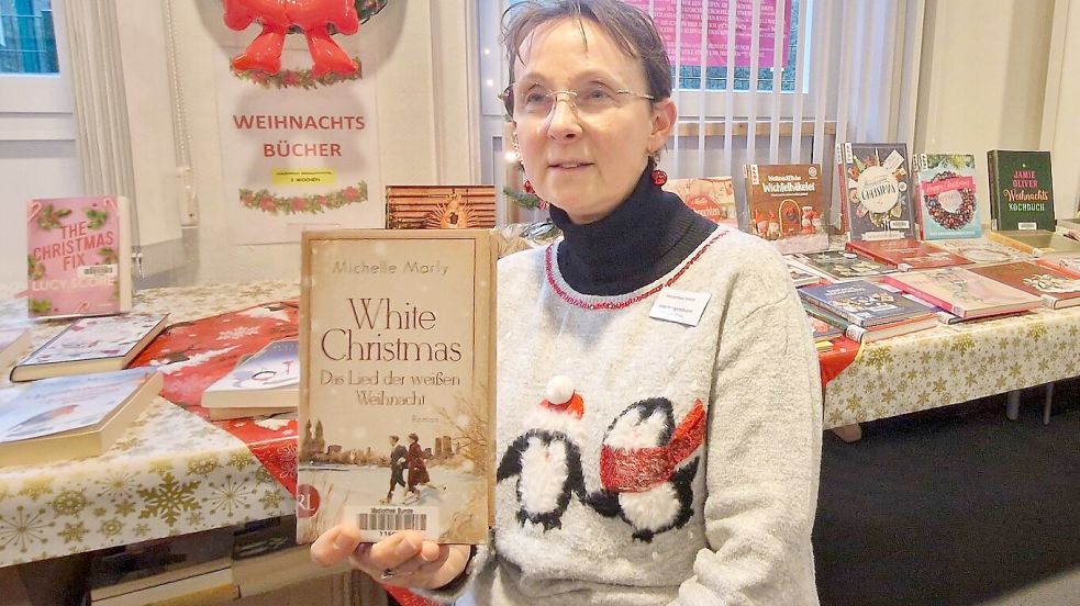 Joke Hoogendoorn, Leiterin der Mediathek in Bunde, empfiehlt ein Buch, das besser zum Fest gar nicht passen könnte, die Geschichte hinter dem weltberühmten Weihnachtslied White Christmas. Foto: Gettkowski