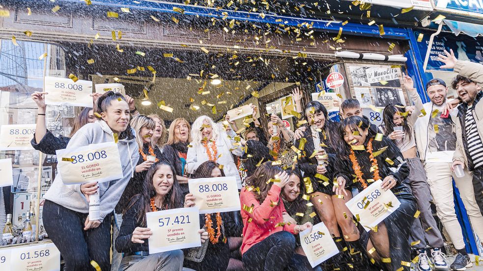 Die letztjährigen Gewinner des ersten Preises der spanischen Weihnachtslotterie feiern ihren Gewinn. Foto: dpa/Carlos Luján