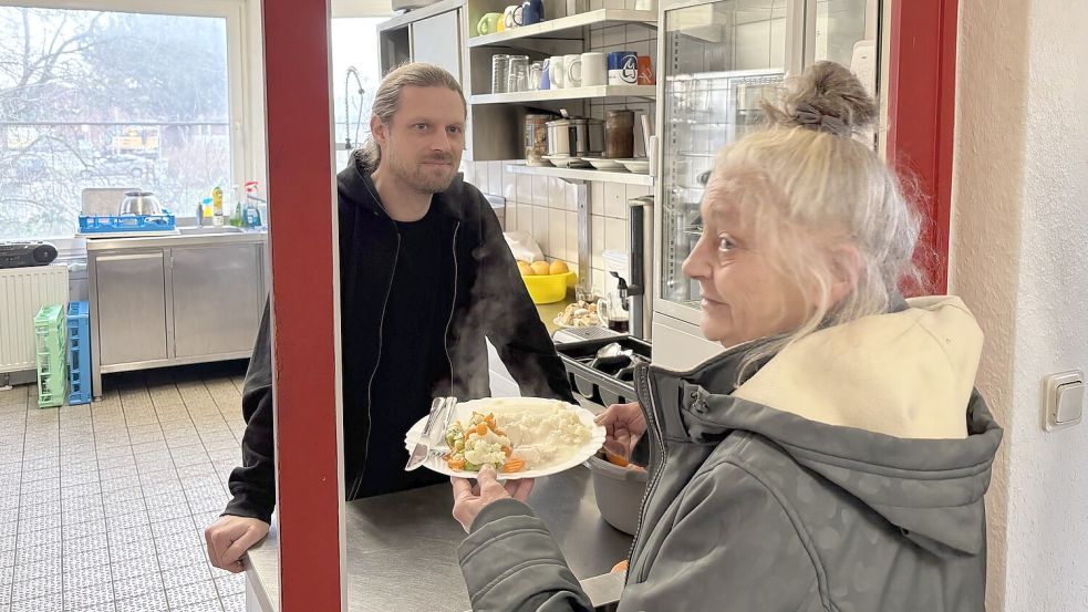 Kurz vor Weihnachten muss es auch mal Hühnerfrikassee tun: Sozialarbeiter Tillmann Schaper teilt das Essen an eine Besucherin aus. Foto: Schuurman