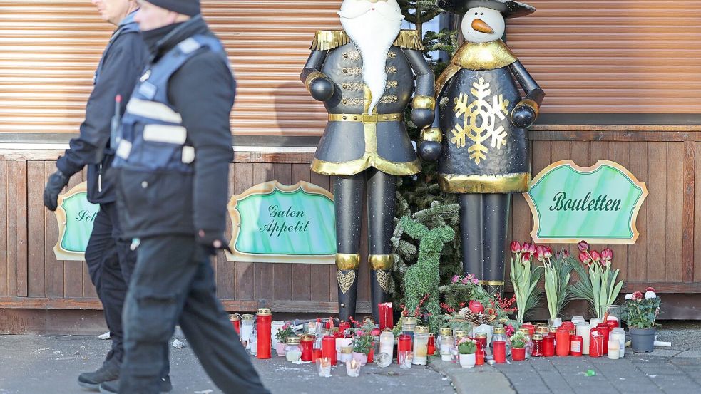 Auch vor den geschlossenen Weihnachtsmarkt-Buden legten Trauernde Blumen ab. Foto: Matthias Bein/dpa