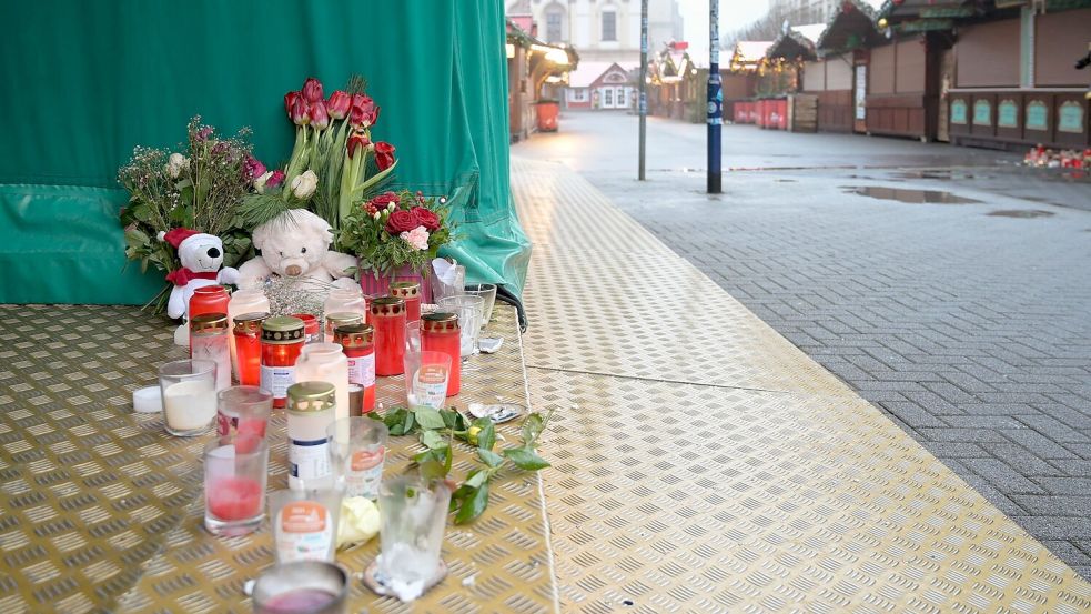 Menschen haben Blumen, Kerzen und Plüschtiere niedergelegt. Foto: Heiko Rebsch/dpa