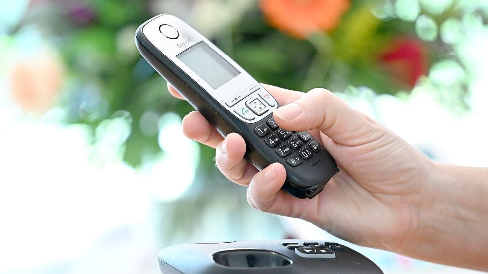 ILLUSTRATION - Eine Frau hölt ein Festnetz-Telefon in ihrer Hand. Foto: Bernd Weissbrod/dpa