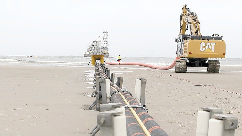 Auf der Nordseite Norderneys laufen die Stromkabel ins Meer, wo sie von dem Kabelverleger im Hintergrund abgerollt werden. Foto: Oltmanns