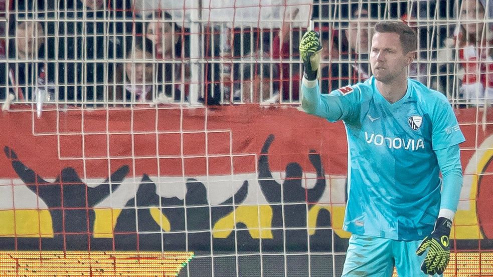 Bochums Keeper Patrick Drewes hält das Feuerzeug hoch, das ihn getroffen hat. Foto: Andreas Gora/dpa