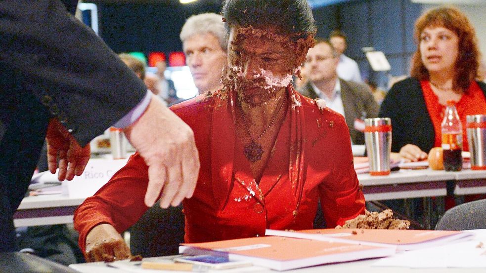 Wagenknecht wird von einer Sahnetorte mitten ins Gesicht getroffen. (Archivbild) Foto: picture alliance / Hendrik Schmidt/dpa-Zentralbild/dpa