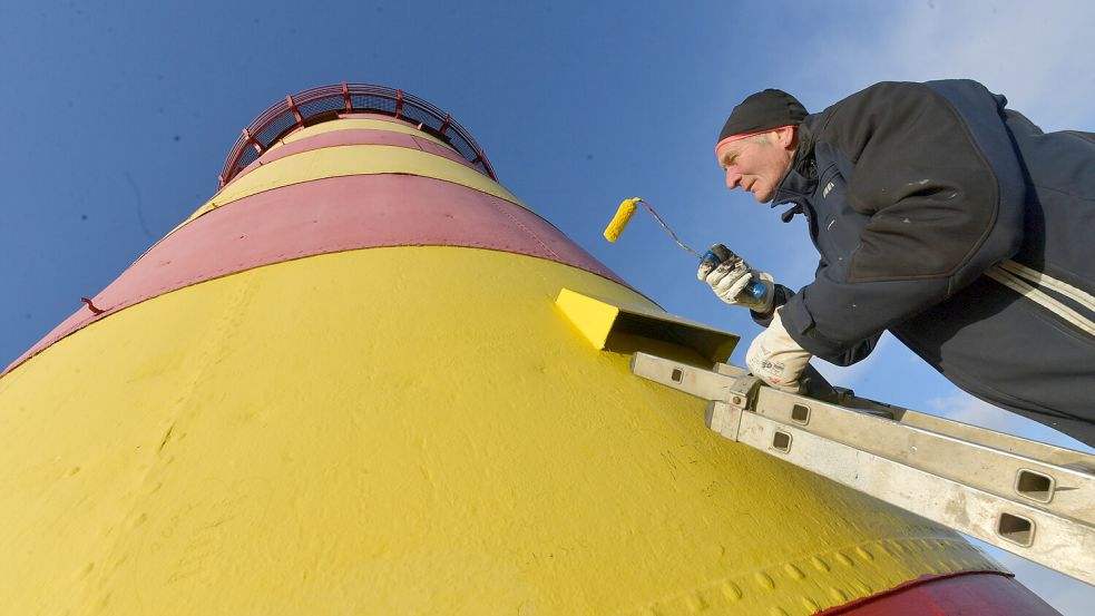 Ulrich Murra von der Deichacht Krummhörn verpasst dem Pilsumer Leuchtturm einen frischen Anstrich in knalligem Gelb. Fotos: Ortgies