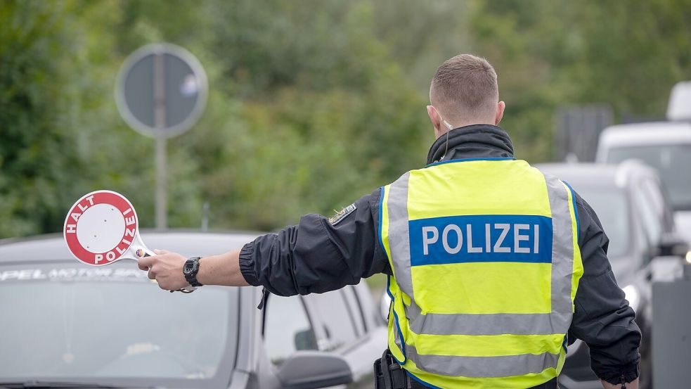 Ein Polizist hält Fahrzeuge an der Grenze zu Deutschland an. Foto: Tittel/dpa