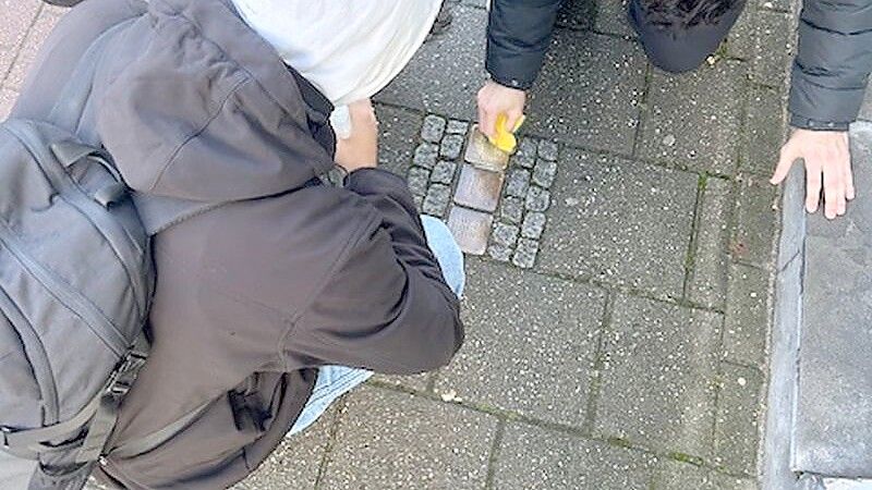 Gymnasiasten der Berufsbildenden Schulen I in Leer reinigen Stolpersteine an der Heisfelder Straße. Die Schule hat die Patenschaft für die Gedenktafeln übernommen. Foto: privat