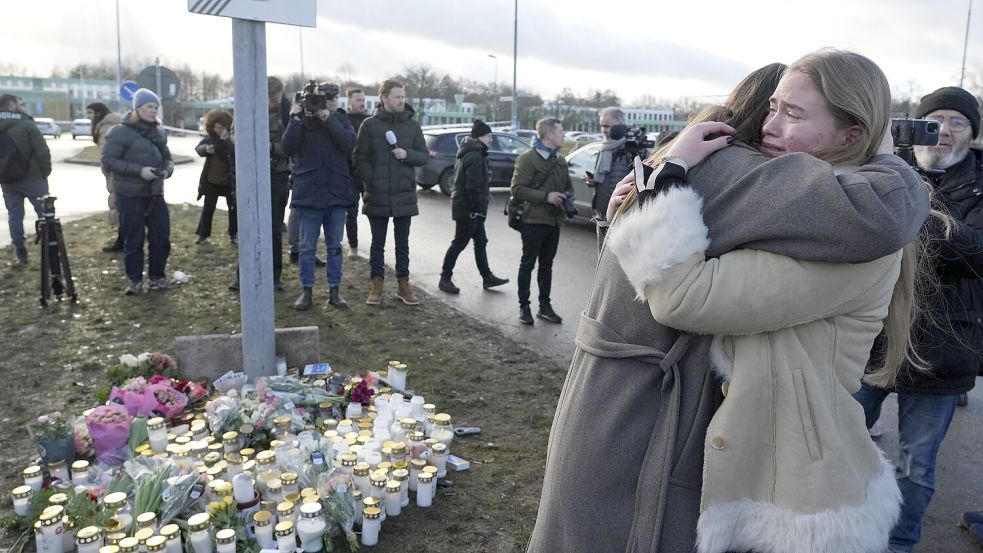 Menschen versammeln sich an einer behelfsmäßigen Gedenkstätte in der Nähe des Bildungszentrums Campus Risbergska. Bei Schüssen an dem Bildungszentrum am Vortag sind mehrere Menschen gestorben. Foto: DPA/Sergei Grits