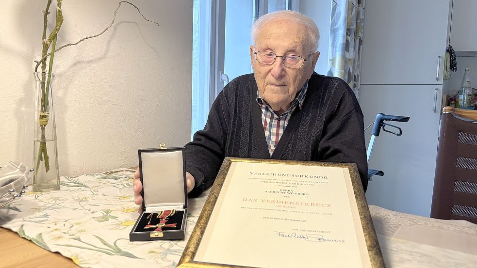 Albrecht Weinberg zeigt sein ihm im September 2017 verliehenes Bundesverdienstkreuz und die dazugehörige Urkunde. Foto: Bothe/Archiv