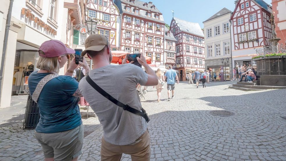 Touristen im Fachwerk-Städtchen Bernkastel-Kues. Die Lust aufs Reisen ist ungebrochen. (Archivbild) Foto: Harald Tittel/dpa